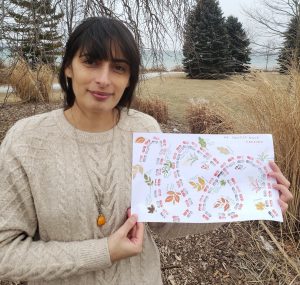 Vergine holding her illustration of her nature walk standing in tall grass in the winter